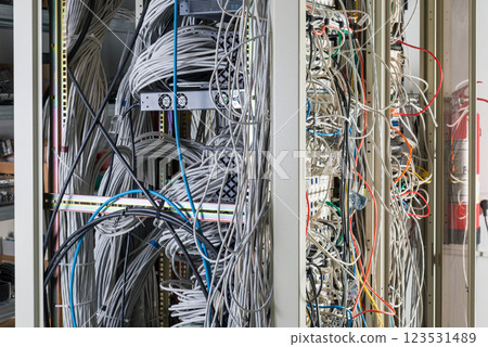 server room rack with tangled network cables creating messy unti 123531489