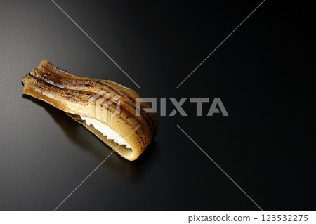 Grilled conger eel sushi photographed against a black background 123532275
