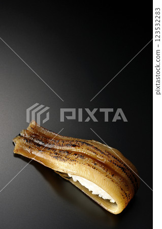 Grilled conger eel sushi photographed against a black background 123532283