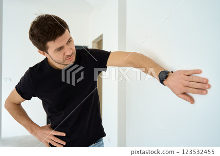 Man Checking Wall Alignment in New Apartment 123532455