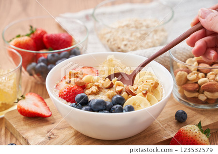 Oatmeal breakfast – topped with fruit and nuts 123532579