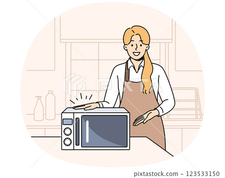 Woman cook demonstrates new microwave oven for heating cold food and drinks without using gas 123533150