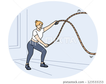 Woman doing fitness using battle rope training at sport center to lose weight or build muscles Woman doing fitness using battle rope training at sport center to lose weight or build muscles 123533153