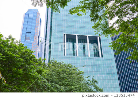 Green foliage framing modern skyscrapers in singapore's bustling cbd 123533474