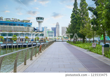 Singapore city skyline rising above waterfront promenade and lush green park 123533475