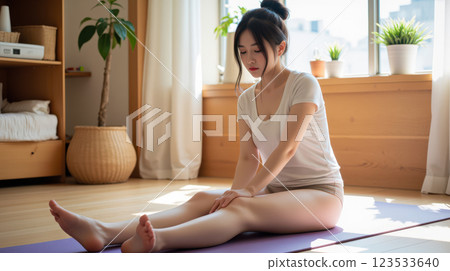 Young Asian woman practicing yoga at home, stretching on mat in peaceful room, morning exercise, healthy lifestyle, relaxation, mindfulness, self-care, wellness, calm meditation 123533640