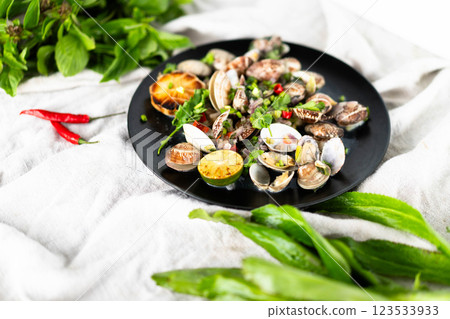 A plate of clams and mussels with herbs, garlic, and chili peppers is a seafood delight. A plate of clams and mussels with herbs, garlic, and chili peppers is a seafood delight. 123533933