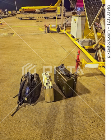 Luggage and equipment on the airport tarmac at night with cargo aircraft. High quality photo 123533965