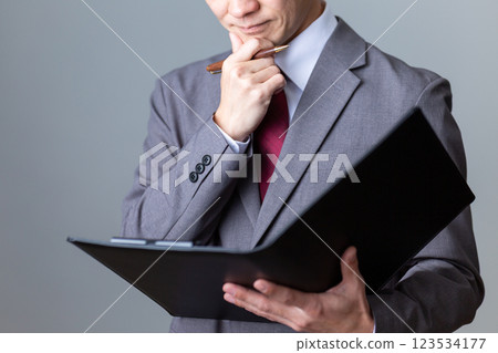 A middle-aged male businessman looking at documents and worrying 123534177