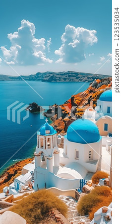 white-washed buildings with blue domes overlooking the  Sea under a clear blue sky, surrounded by warm orange-tinted cliffs and serene beauty 123535034