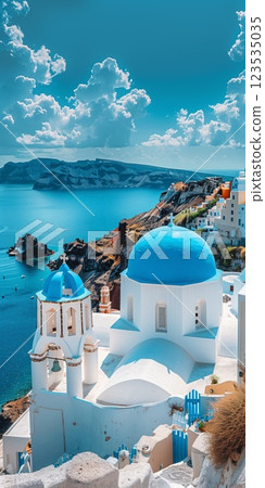 Iconic blue-domed churches of overlooking the azure Sea, framed by dramatic cliffs and bright fluffy clouds under a vibrant summer sky 123535035