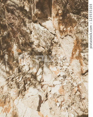 Natural background. Closeup edged shabby cliff cracks. Gray-brown stone rock texture of mountains. Vintage and faded matt style colour in tinted photo. Concept of geolog, mountaineering or hard work 123535103