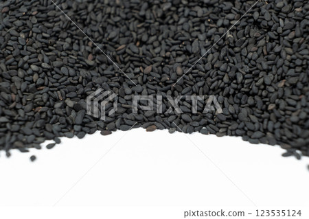 Black sesame seeds scattered on a white background place for text Black sesame seeds scattered on a white background place for text 123535124