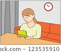 A young woman rejoices as she looks at her bankbook with increased interest due to an interest rate hike 123535910