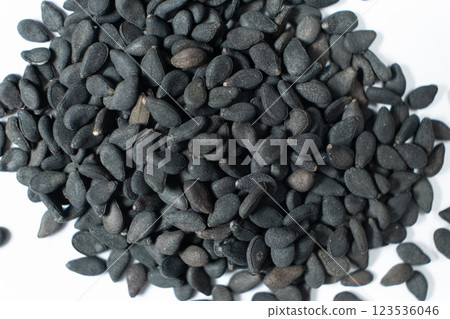 Black sesame seeds scattered on a white background macro top view 123536046
