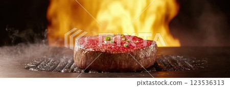 Sizzling juicy steak grilling with flames and smoke creating dramatic lighting effects Sizzling juicy steak grilling with flames and smoke creating dramatic lighting effects 123536313