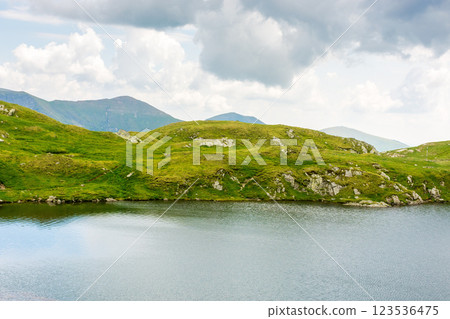 alpine lake capra in summer. beautiful view. cloudy weather. scenery of fagaras ridge. carpathian mountain range. romania landscape. european travel destination 123536475
