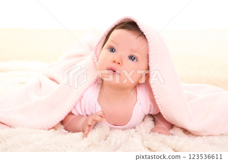 baby girl under hidden pink blanket on white fur baby girl under hidden pink blanket on white fur 123536611