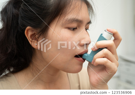 Asian woman use Asthma and chronic obstructive pulmonary disease COPD, Asian young man using metered dose inhaler MDI. 123536906