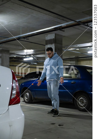 Person in Underground Parking Garage Figure Out of Stolen Car 123537083