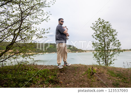 Father Holding Baby by Tranquil Lake 123537093