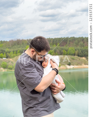Father Holding Baby by Tranquil Lake 123537151