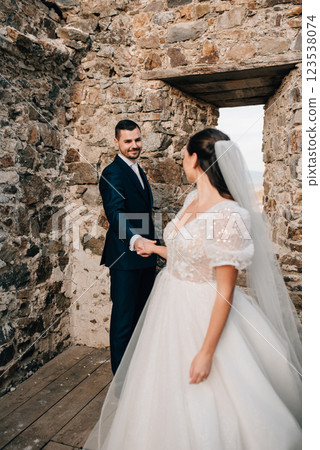 Portrait of beautiful wedding couple standing outside near ruins. 123538074