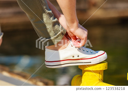 Woman tying laces in sneakers outdoors 123538218