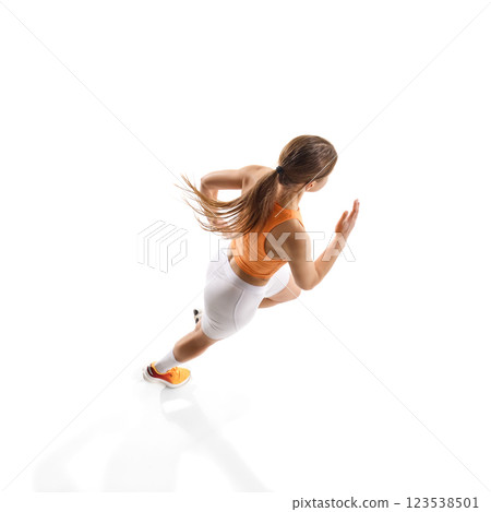 Focused woman running, achieving fitness goals with determination, training against white studio background. 123538501