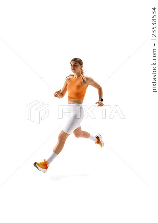 Young sportive woman in sportswear, dedicated athlete sprinting with full force against white studio background. Young sportive woman in sportswear, dedicated athlete sprinting with full force against white studio background. 123538534