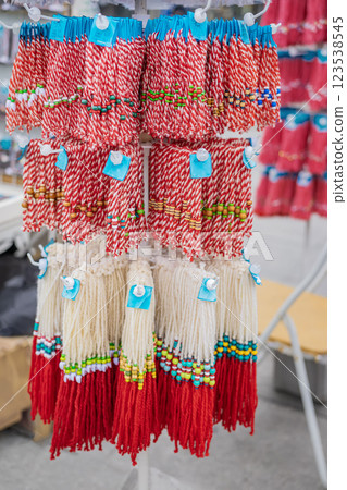 Rows of Martenitsa tassels displayed at traditional Bulgarian market. Red and white handmade charms symbolize beginning of spring, health, luck, prosperity. Baba Marta - first day of spring 123538545