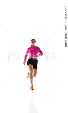 Front view image of young woman in sportswear in motion, training, running against white studio background. Cardio workout 123538558