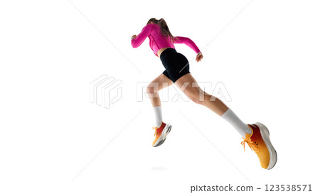 Low angle view of young female runnier in motion, running, showing progress, movement, and athletic ambition against white studio background. 123538571