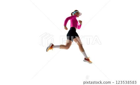 Dynamic movement of sportive woman, runner in motion, training, competing against white studio background. 123538583
