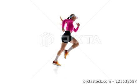 Side view image of young sportive woman in sportswear and cap, determined athlete in motion, running against white studio background. Side view image of young sportive woman in sportswear and cap, determined athlete in motion, running against white studio background. 123538587