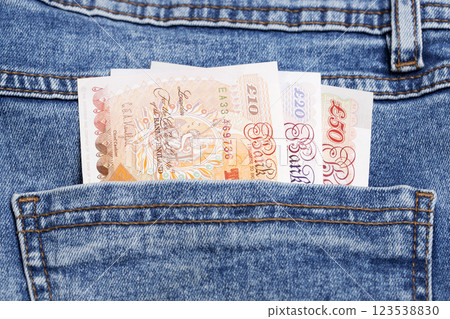 British pound in the pocket of blue jeans British pound in the pocket of blue jeans 123538830
