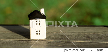 A small house stands on a bench in the park. Real estate, affordable housing and mortgage lending concept. Sale, purchase and rental of apartments. Selective focus. Place for text 123538840