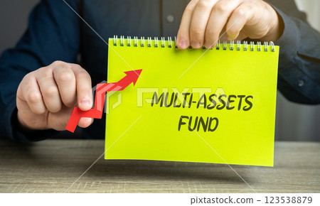 Multi-assets fund concept. Investment fund that allocates its portfolio across a diverse range of asset classes, such as stocks, bonds, real estate, and commodities. Notebook and arrow in male hands Multi-assets fund concept. Investment fund that allocates its portfolio across a diverse range of asset classes, such as stocks, bonds, real estate, and commodities. Notebook and arrow in male hands 123538879