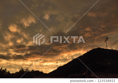 落日餘暉灑在山間，色彩詭異 123538915