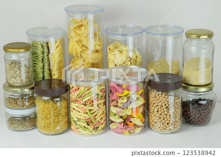 Variety of multi-colored pasta and and other groceries in glass containers. Types of uncooked pasta, chickpeas, rice, sesame, bulgur, hemp porridge and sunflower seeds. Storing different types of past Variety of multi-colored pasta and and other groceries in glass containers. Types of uncooked pasta, chickpeas, rice, sesame, bulgur, hemp porridge and sunflower seeds. Storing different types of past 123538942