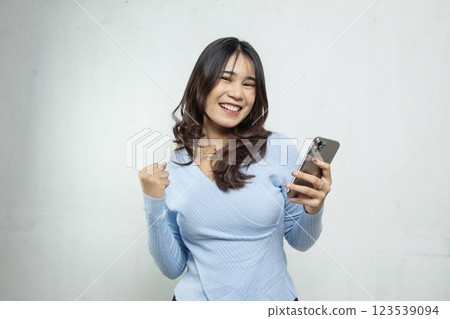portrait of Young Asian woman happy and excited with smartphone getting good news, casual blue style with isolated on white 123539094