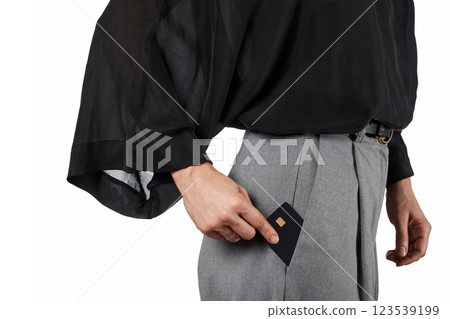 Modern business woman putting black premium credit bank card in grey pants pocket on white background. Money finance Modern business woman putting black premium credit bank card in grey pants pocket on white background. Money finance 123539199