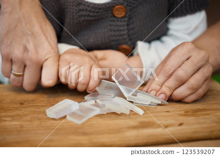 close-up of hands of mother helps her little child girl using knife for preparing hand-made soap, art workshops for children. close-up of hands of mother helps her little child girl using knife for preparing hand-made soap, art workshops for children. 123539207