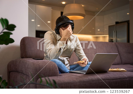 Freelancer stressed man suffer from headache and working with laptop at home 123539267