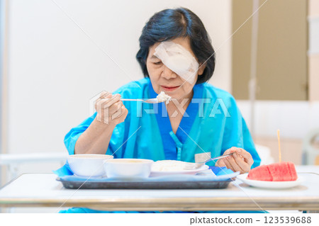Senior Woman eating food after eye surgery in hospital . Eye disease, Cataract,  Glaucoma, Age Related Macular Degeneration, Diabetic Retinopathy, Lasik, World Glaucoma day and health treatment 123539688