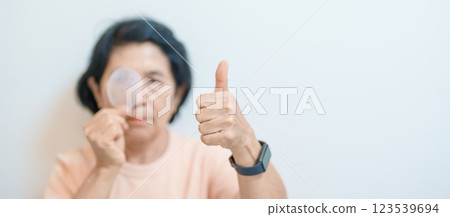 Elderly Woman with eye protective shield after eye surgery. Eye disease, Cataract, Glaucoma, Age Related Macular Degeneration, Diabetic Retinopathy, Vitreous, Lasik, World Glaucoma day and health Elderly Woman with eye protective shield after eye surgery. Eye disease, Cataract, Glaucoma, Age Related Macular Degeneration, Diabetic Retinopathy, Vitreous, Lasik, World Glaucoma day and health 123539694