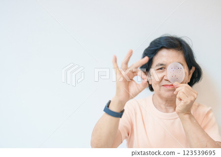 Elderly Woman with eye protective shield after eye surgery. Eye disease, Cataract, Glaucoma, Age Related Macular Degeneration, Diabetic Retinopathy, Vitreous, Lasik, World Glaucoma day and health Elderly Woman with eye protective shield after eye surgery. Eye disease, Cataract, Glaucoma, Age Related Macular Degeneration, Diabetic Retinopathy, Vitreous, Lasik, World Glaucoma day and health 123539695