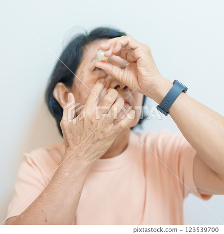 Elderly Woman use ophthalmic solutions or Eye Drops after eye surgery. Eye disease, Cataract, Glaucoma, Age Related Macular Degeneration, Diabetic Retinopathy, World Glaucoma day and health treatment Elderly Woman use ophthalmic solutions or Eye Drops after eye surgery. Eye disease, Cataract, Glaucoma, Age Related Macular Degeneration, Diabetic Retinopathy, World Glaucoma day and health treatment 123539700