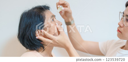 Elderly Woman use ophthalmic solutions or Eye Drops after eye surgery. Eye disease, Cataract,  Glaucoma, Age Related Macular Degeneration, Diabetic Retinopathy, World Glaucoma day and health treatment 123539720