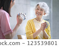 微笑的老年婦女拿著鈴鐺和護理人員音樂治療活動圖片 123539801